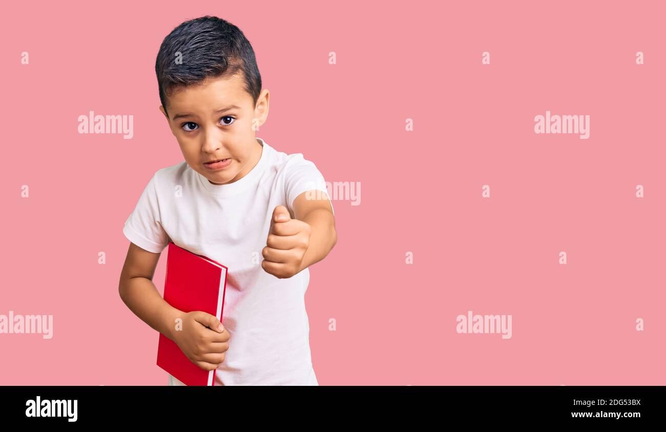 Little cute boy kid reading a book annoyed and frustrated shouting with ...