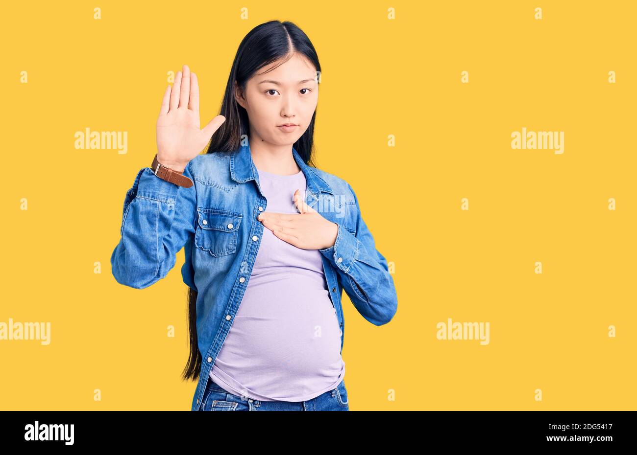 Young beautiful chinese woman pregnant expecting baby swearing with