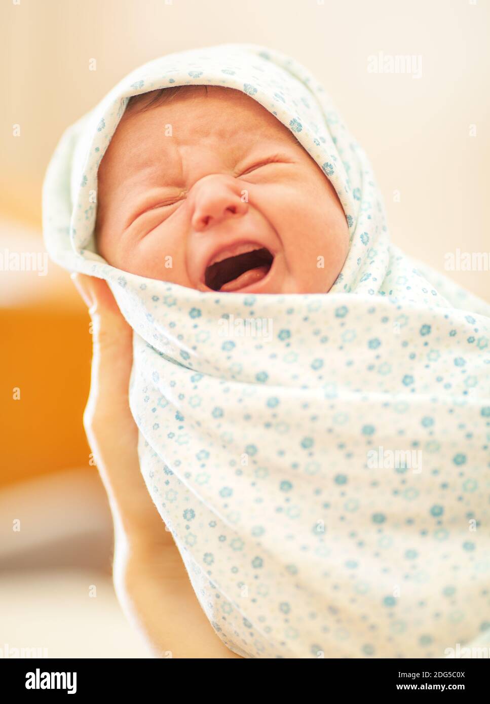 Crying newborn in mothers hands Stock Photo