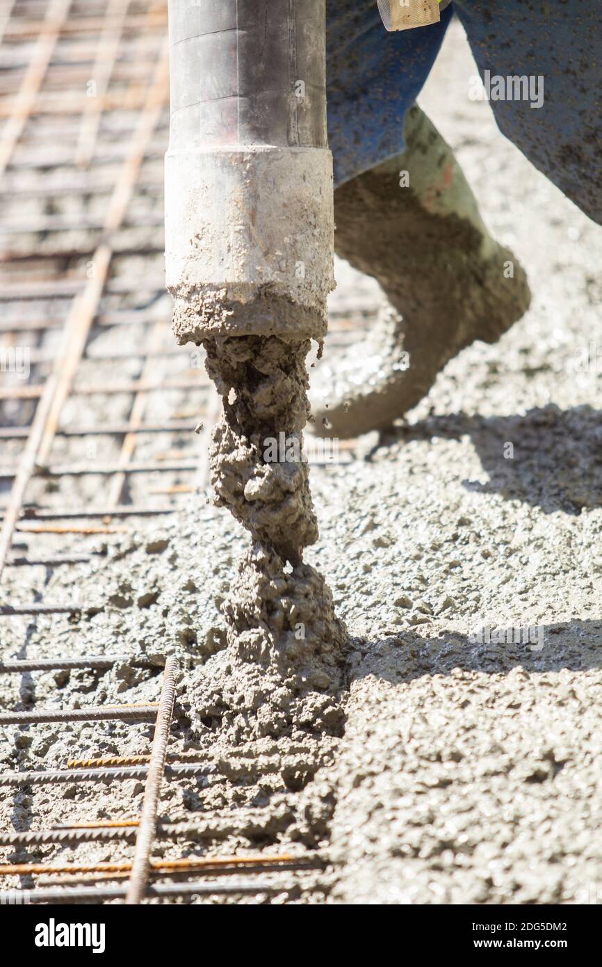 Worker filling the foundation slab of a building under construction