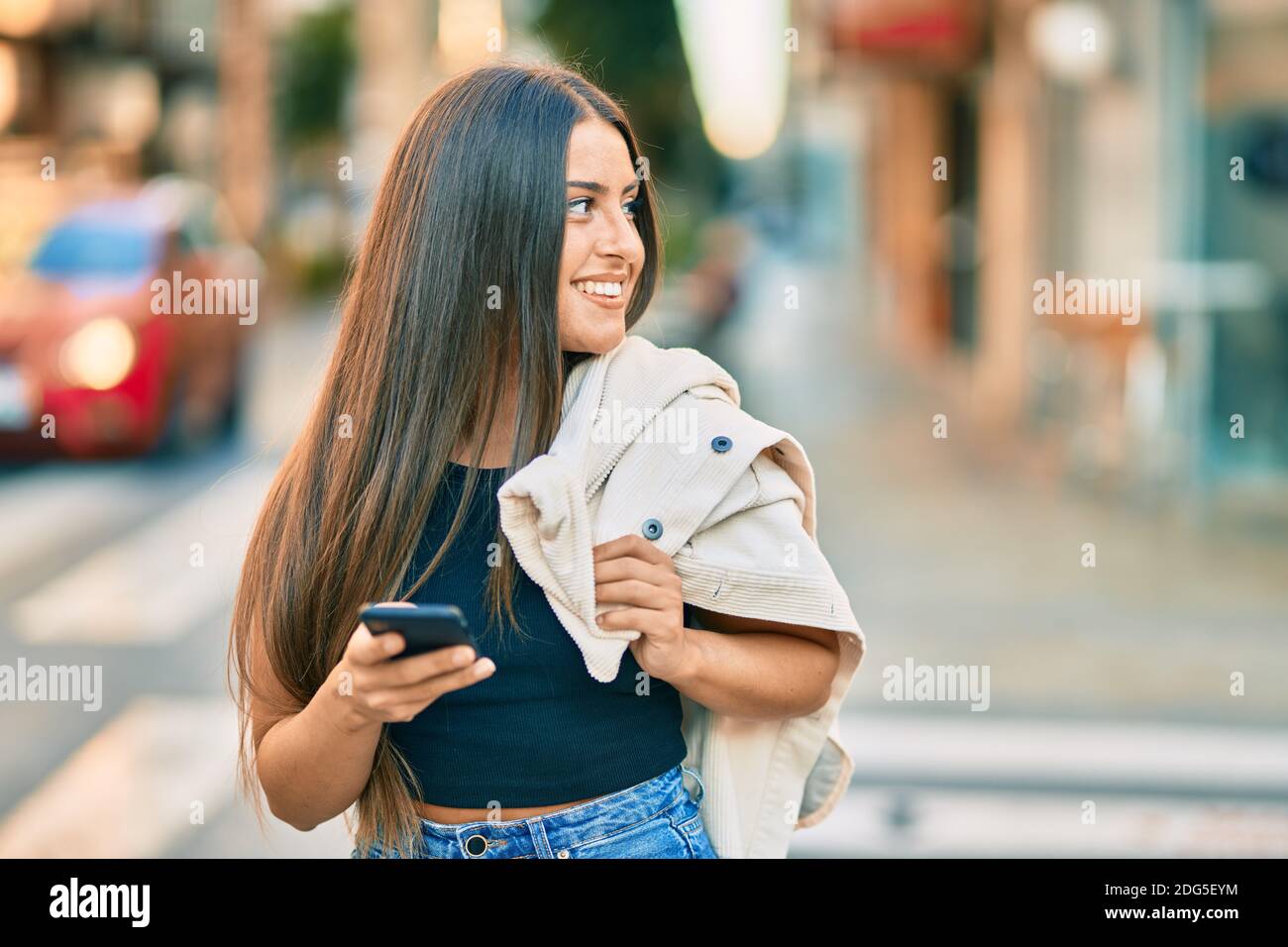 Young hispanic girl smiling happy using smartphone at the city Stock ...