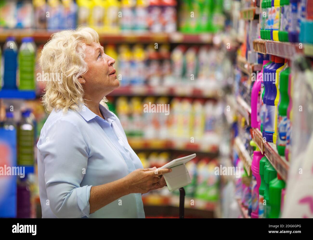 Woman with pad shopping for household detergents Stock Photo