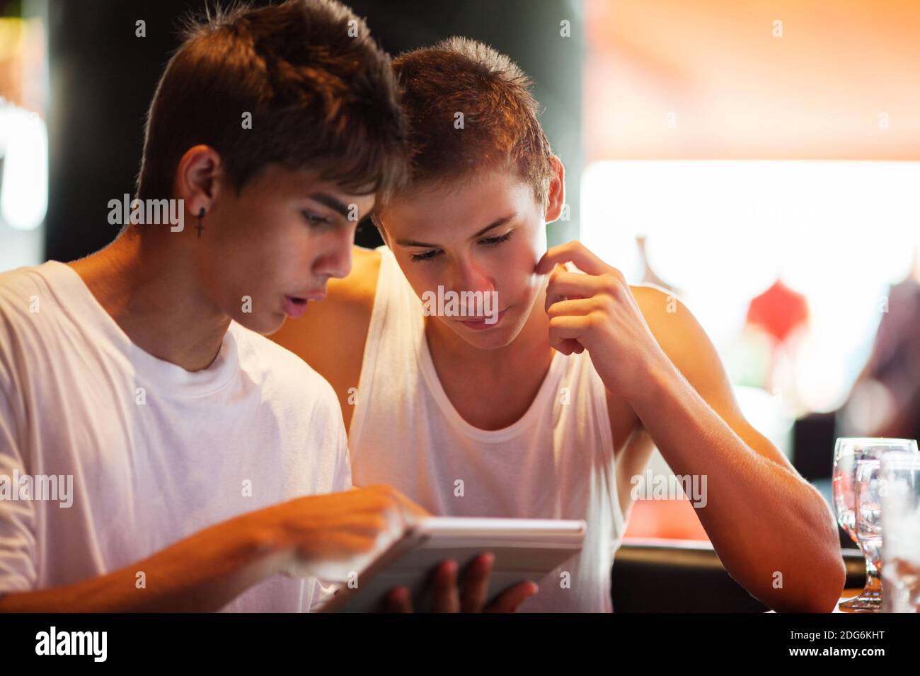 Young men searching on the internet with pad in cafe Stock Photo