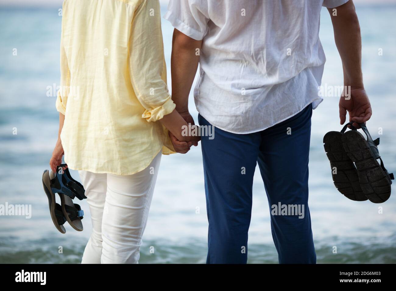 Couple holding hands at the seaside Stock Photo - Alamy