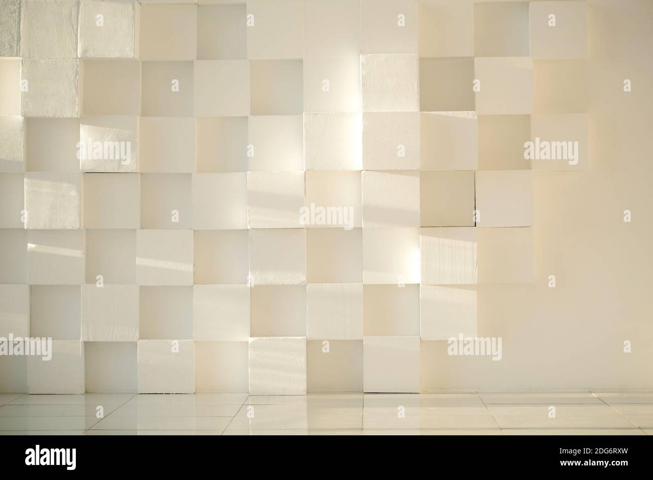 White painted concrete wall made of cubes with tiled floor Stock Photo