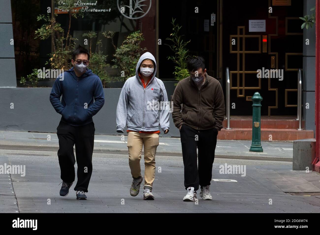 Melbourne, Australia, 24 August, 2020. Three men wearing facemasks are seen ignoring physical distancing during COVID-19 in Melbourne, Australia. Premier Daniel Andrews announced yesterday his plans to extend Victoria's State of Emergency for another 12 months giving his government and his Chief Health Officer, Brett Sutton, unprecedented powers as well as the ability to curtail democratic checks and balances. It comes as case numbers continue to fall. Responsibility for the current wave the State is experiencing rests solely on the Andrews Governments shoulders and some are saying that if th Stock Photo