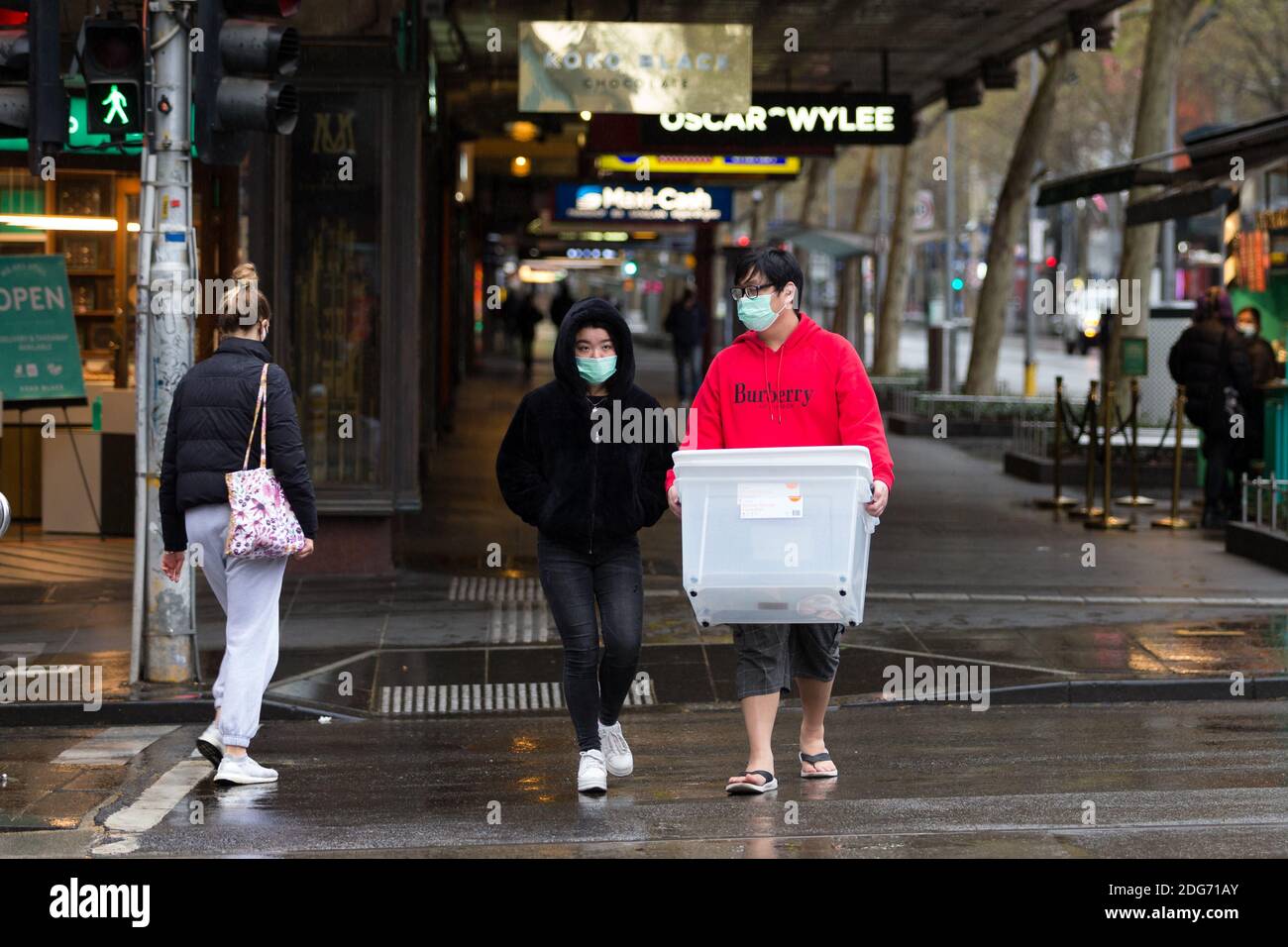 Melbourne, Australia, 12 September, 2020.  A couple walks across an intersection in the rain during Stage 4 Restrictions on September 12, 2020 in Melbourne, Australia. Stage 4 restrictions are in place from 6pm on Sunday 2 August for metropolitan Melbourne. This includes a curfew from 8pm to 5am every evening. During this time people are only allowed to leave their house for work, and essential health, care or safety reasons. Despite this, multiple protests are being arranged to push back against the draconian restrictions in place within metropolitan Melbourne. A Freedom Walk was arranged to Stock Photo