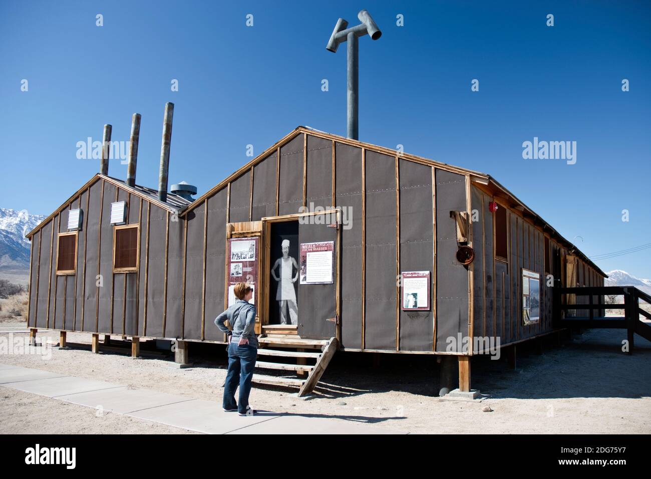 Woman reads about the Block 14 mess hall at Manzanar Nat. Historic Site, a camp where Japanese Americans were interned in World War Two in California. Stock Photo
