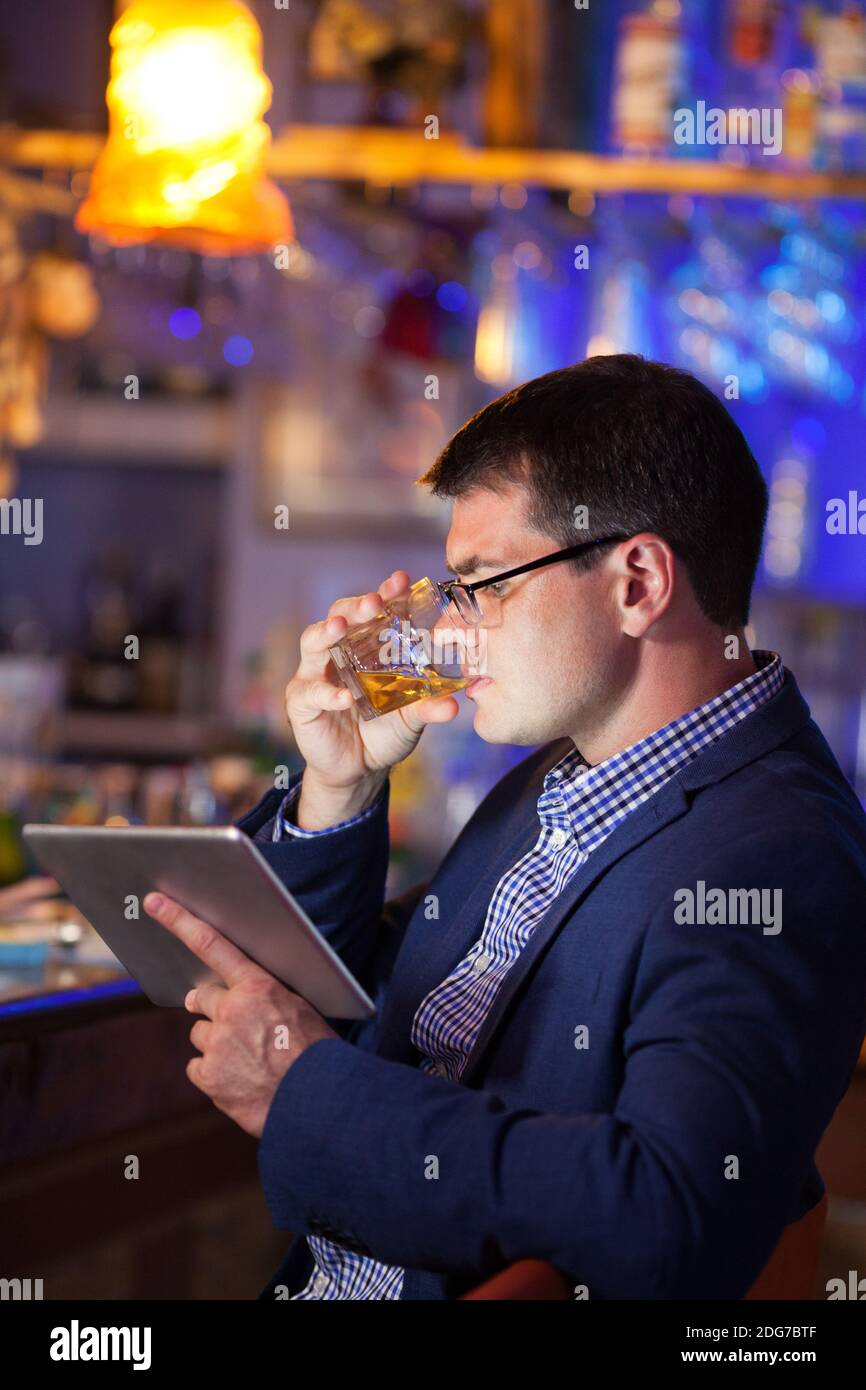 Businessman enjoying a drink at a club Stock Photo