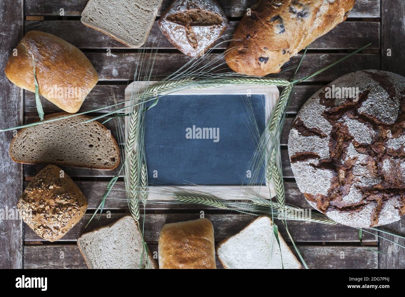 Various types of bread with a blackboard on a wooden table Stock Photo
