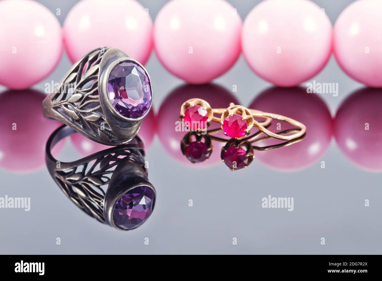 Vintage silver ring with a large amethyst on a background of pink beads with large beads Stock Photo