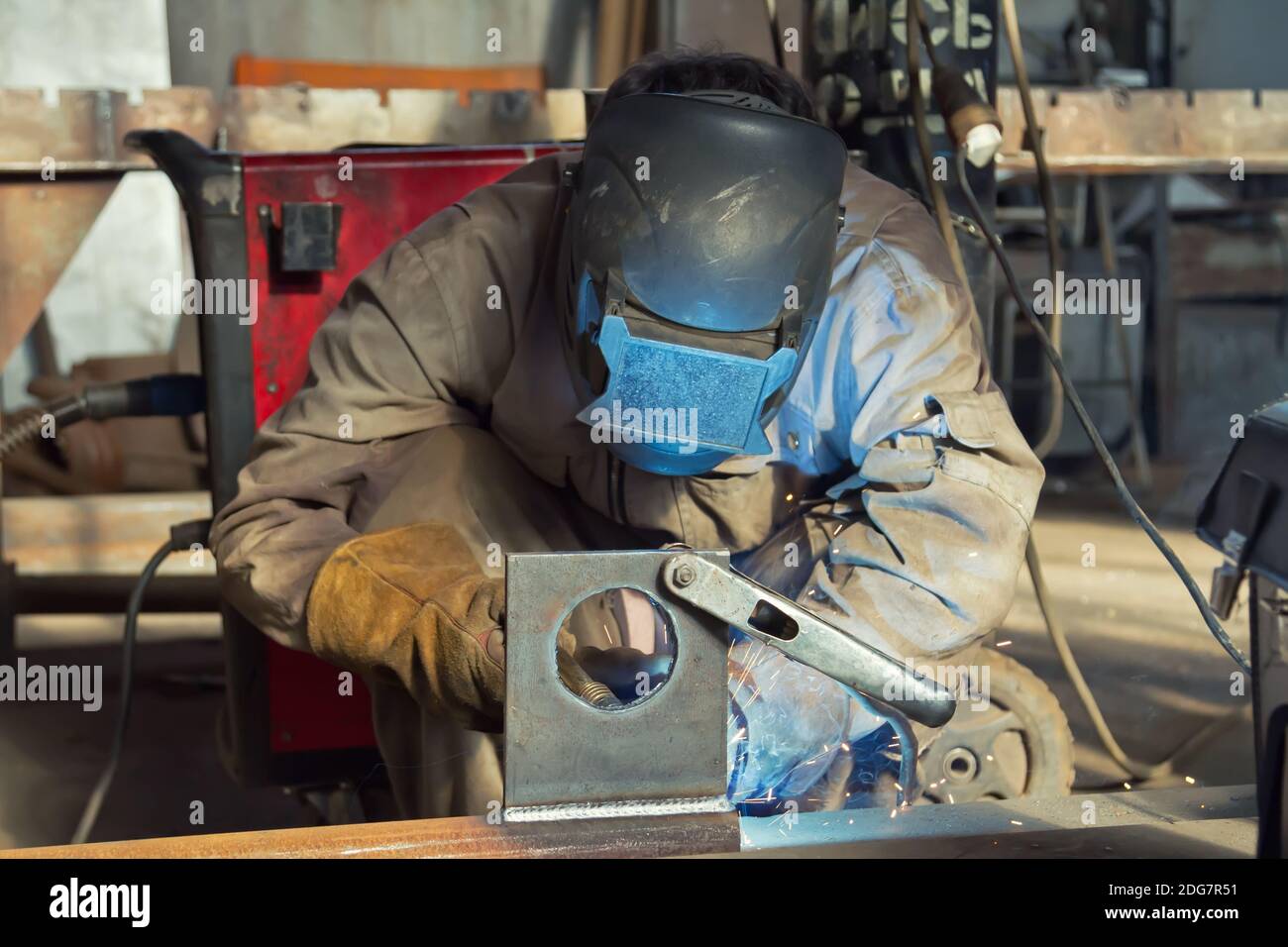 Welder in the mask and protective clothing is gaining increased cladding weld Stock Photo