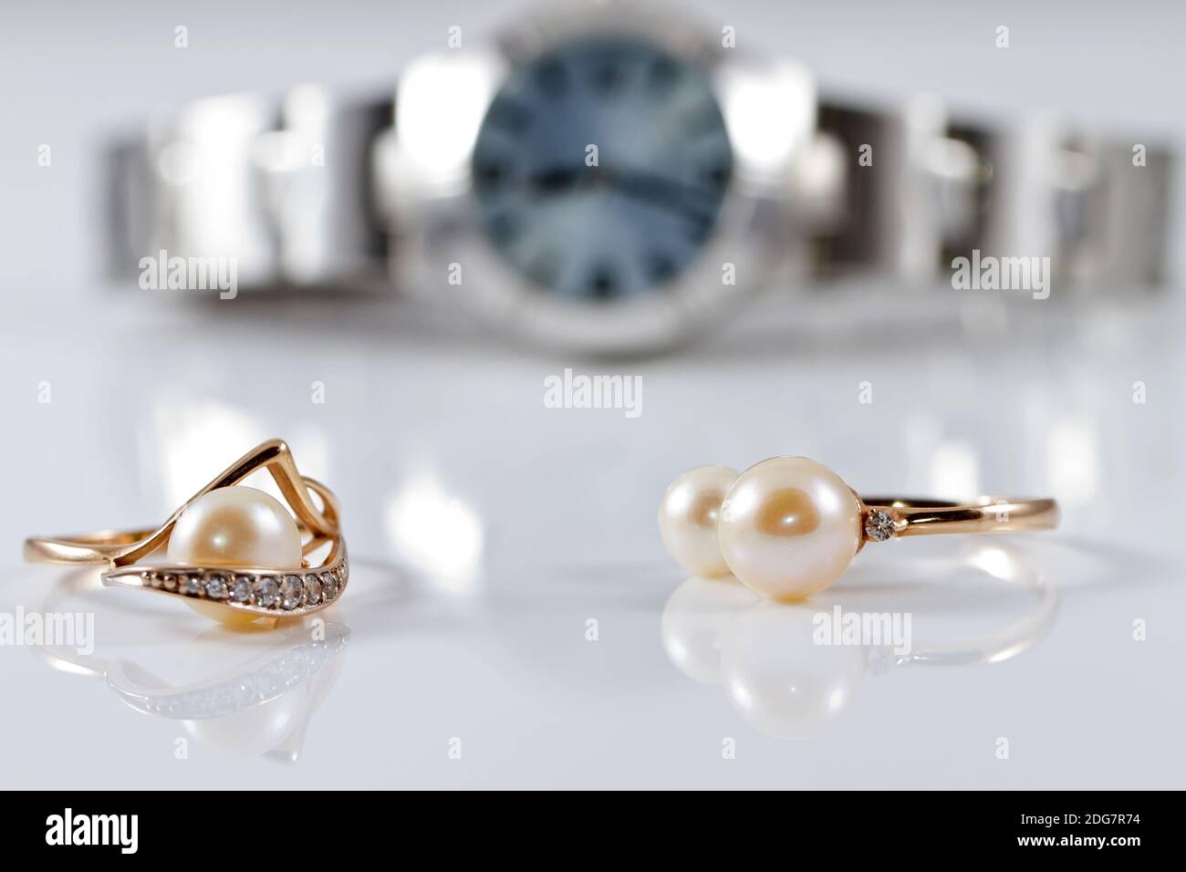 Gold rings with pearls of different styles on the background watches Stock Photo