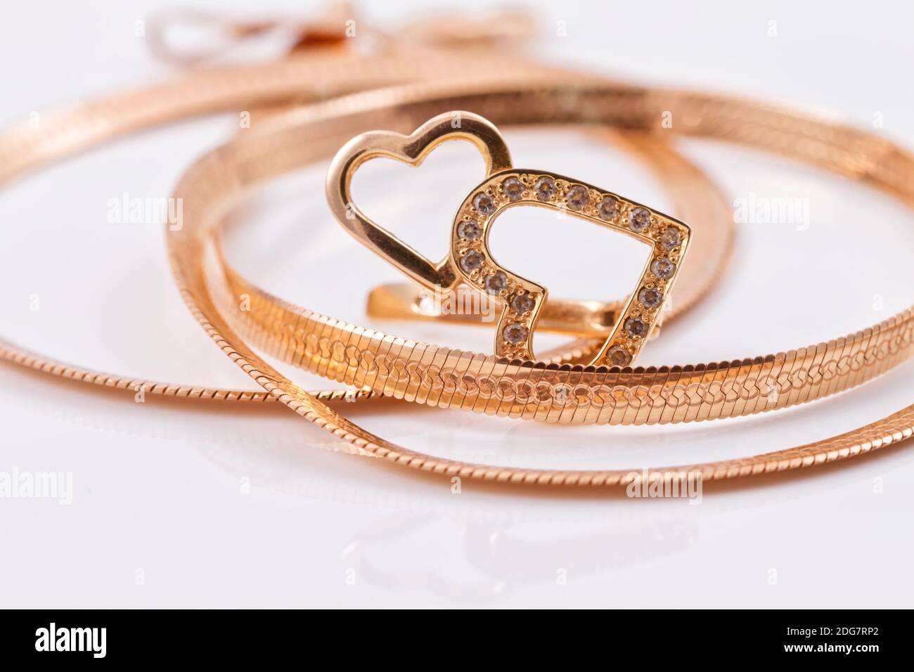 Gold earrings in the shape of a heart and a gold chain Stock Photo