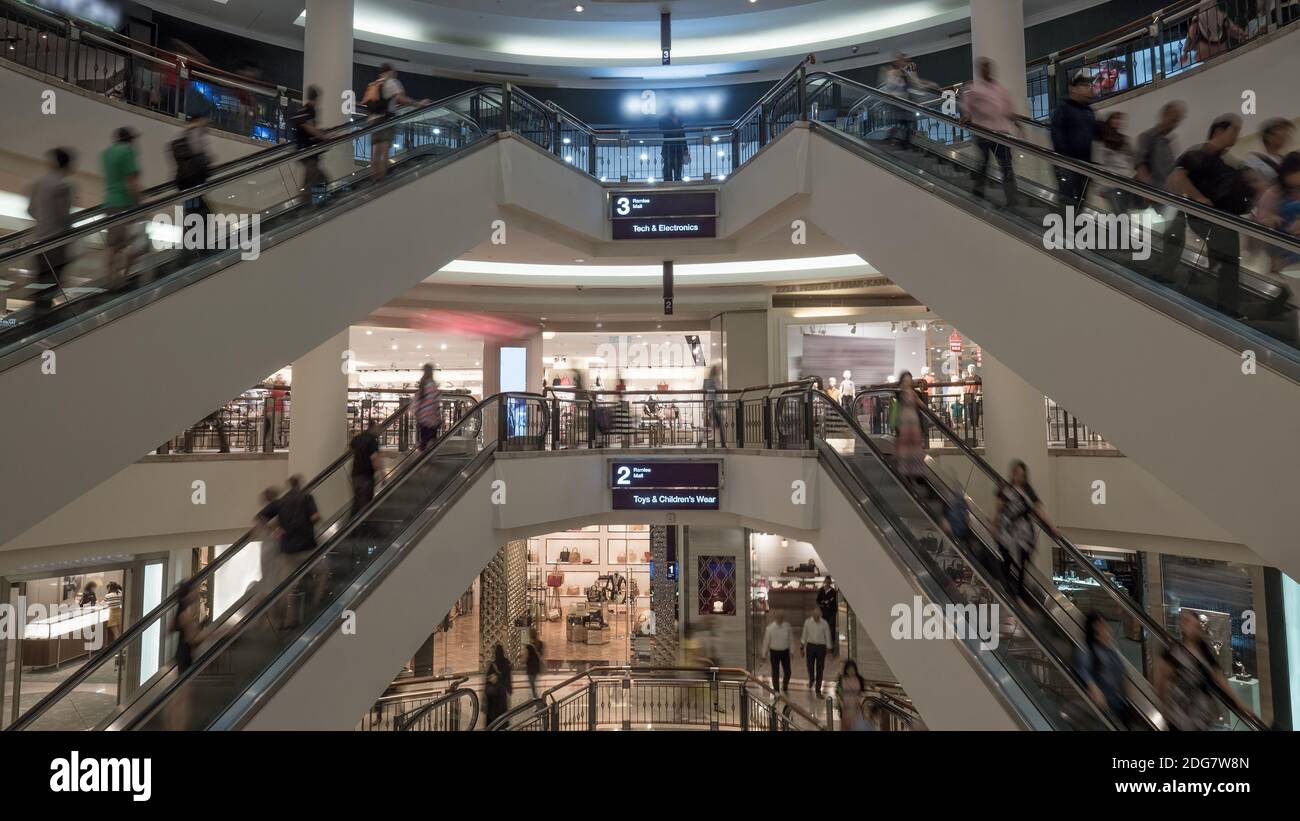 People on escalators in shopping centre Stock Photo
