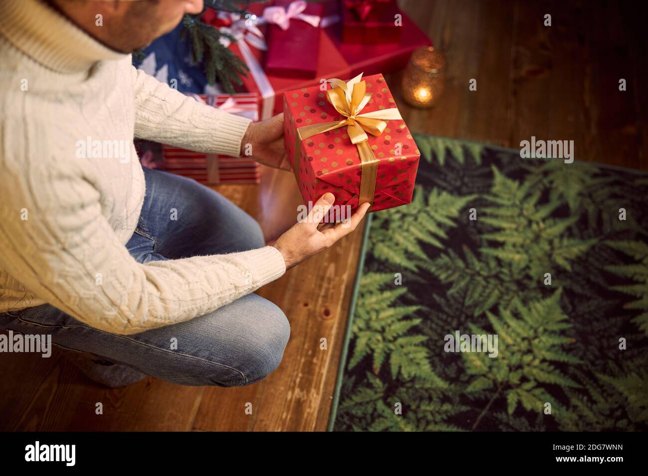 Confident male with gift in arms in winter Christmas holidays in home apartments Stock Photo