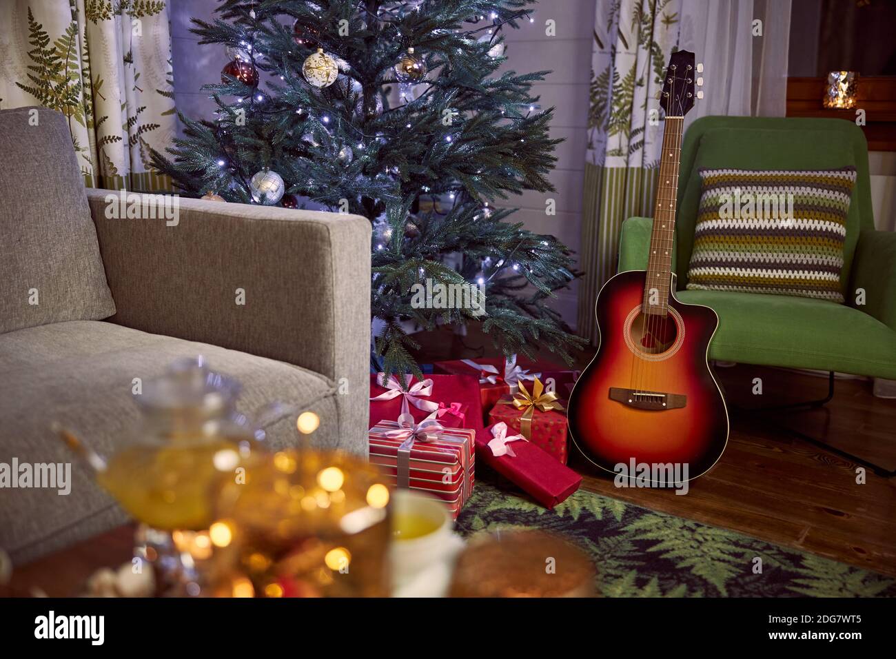 Guitar with decorated Christmas Tree in the background Stock Photo