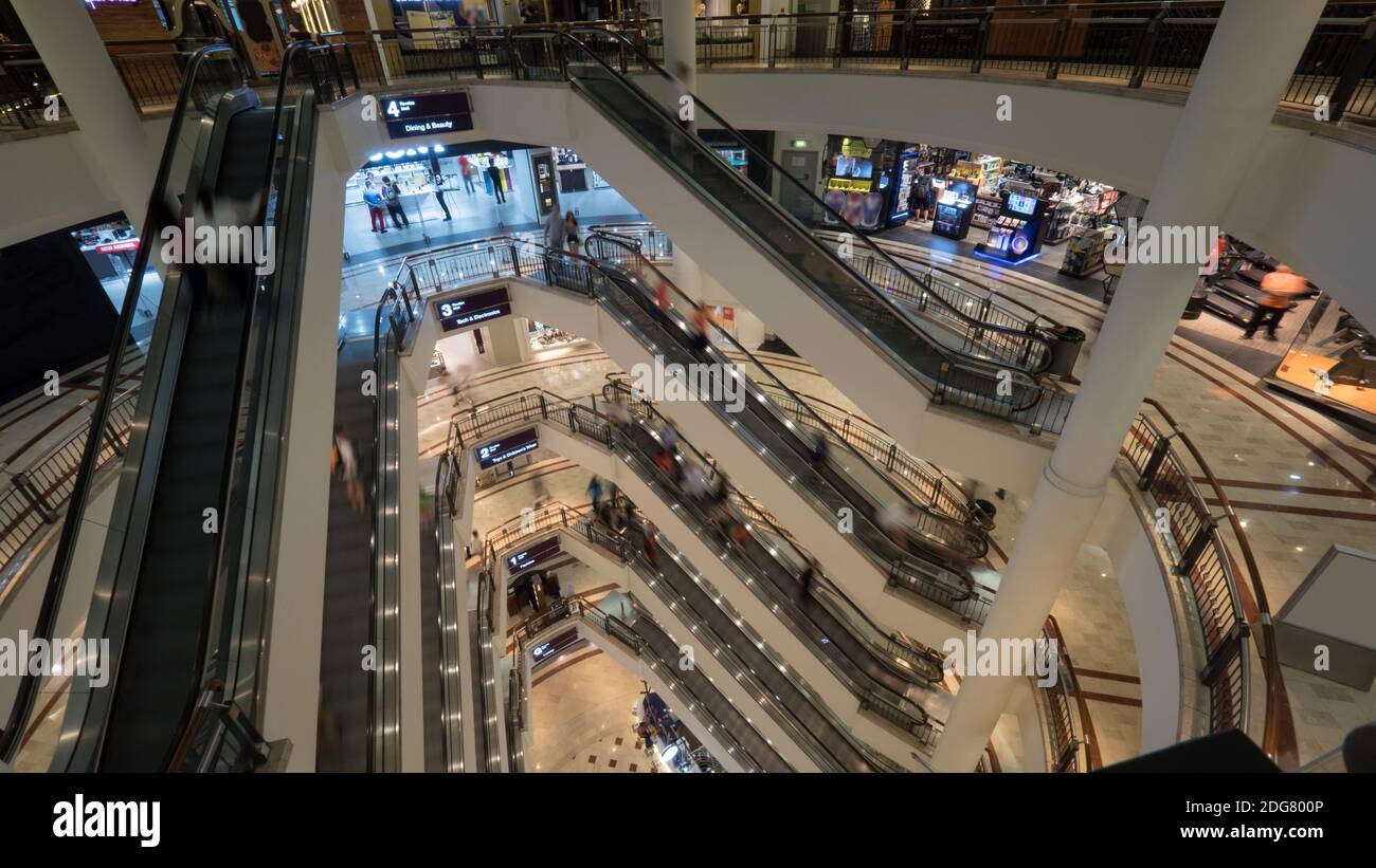People on escalators in multistorey shopping mall Stock Photo