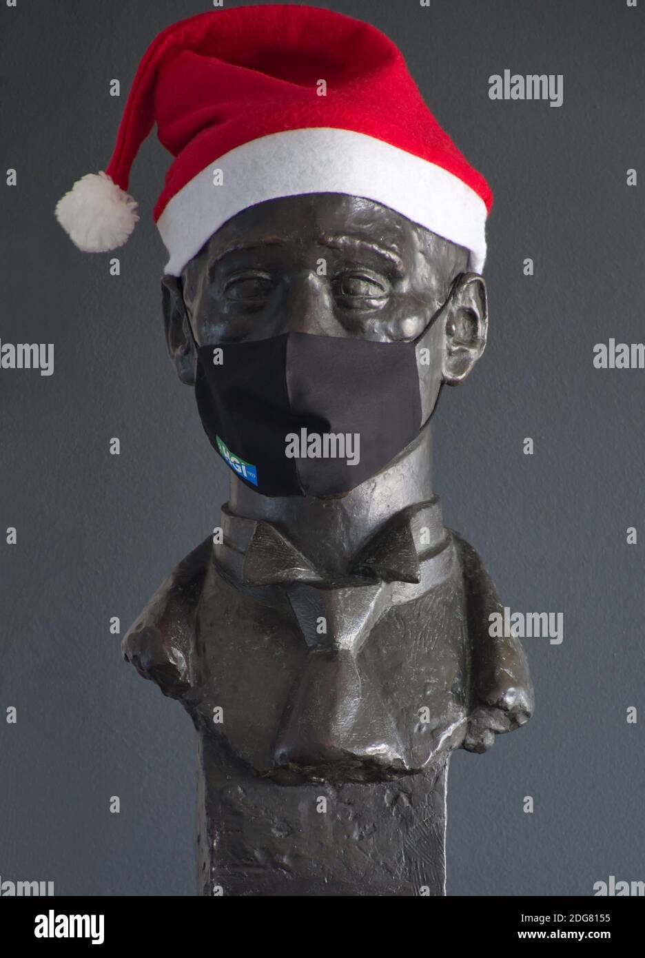 Man's bust with Santa hat and face mask at the entrance of the company Stock Photo