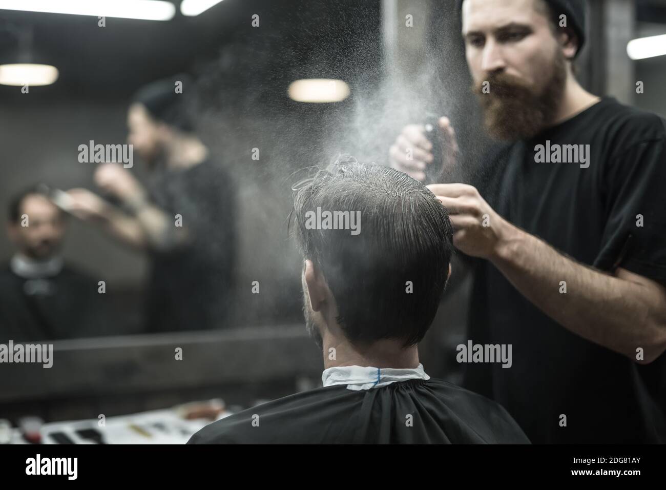 Barber is using spray bottle Stock Photo Alamy