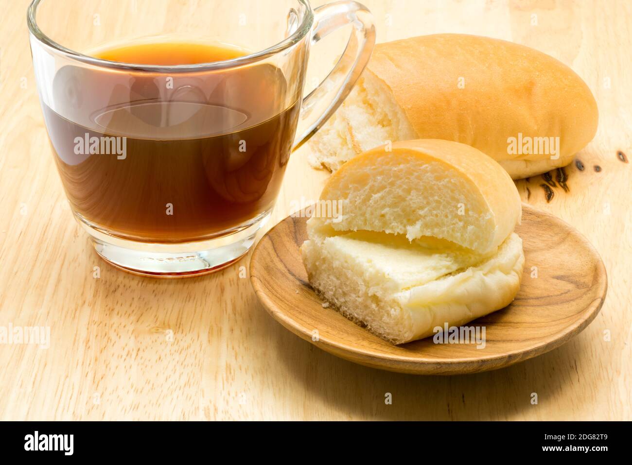 Hotdog bread filled with sweetened butter cream and a cup of coffee Stock Photo