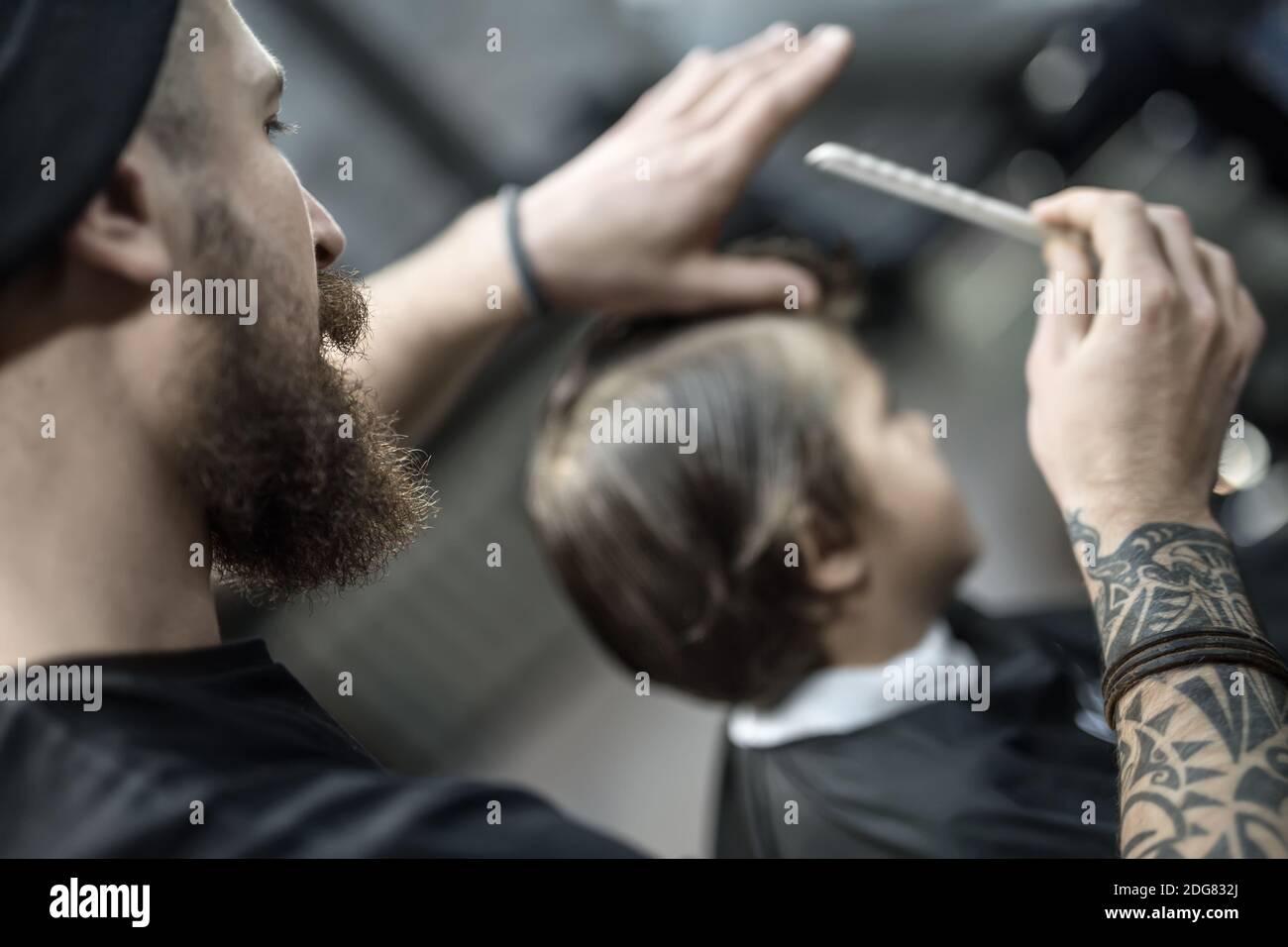 Barber and his client in barbershop Stock Photo