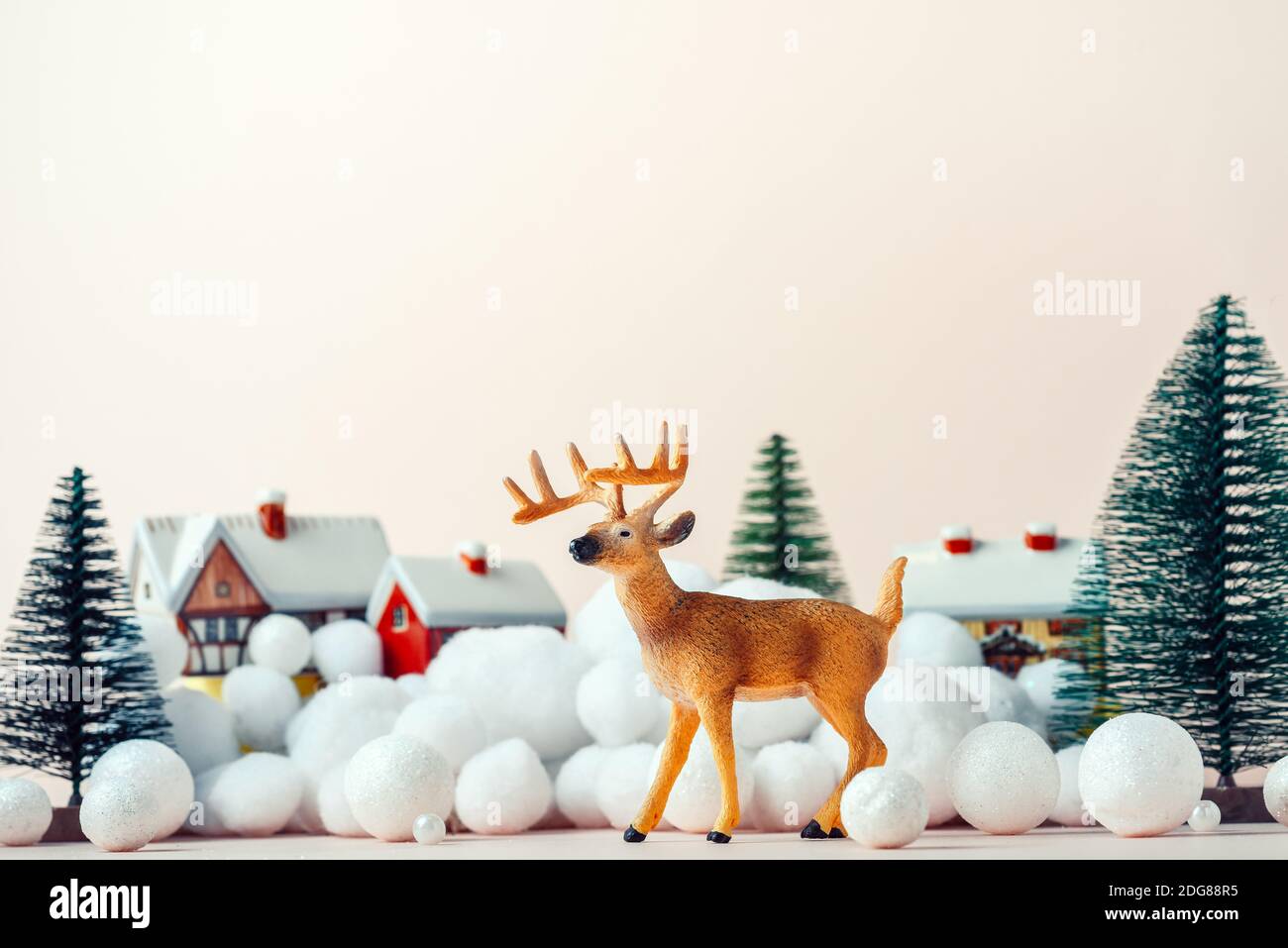 Beautiful deer on Christmas Eve on the background of rural houses, Christmas mockup. Merry Christmas and New Years concept Stock Photo