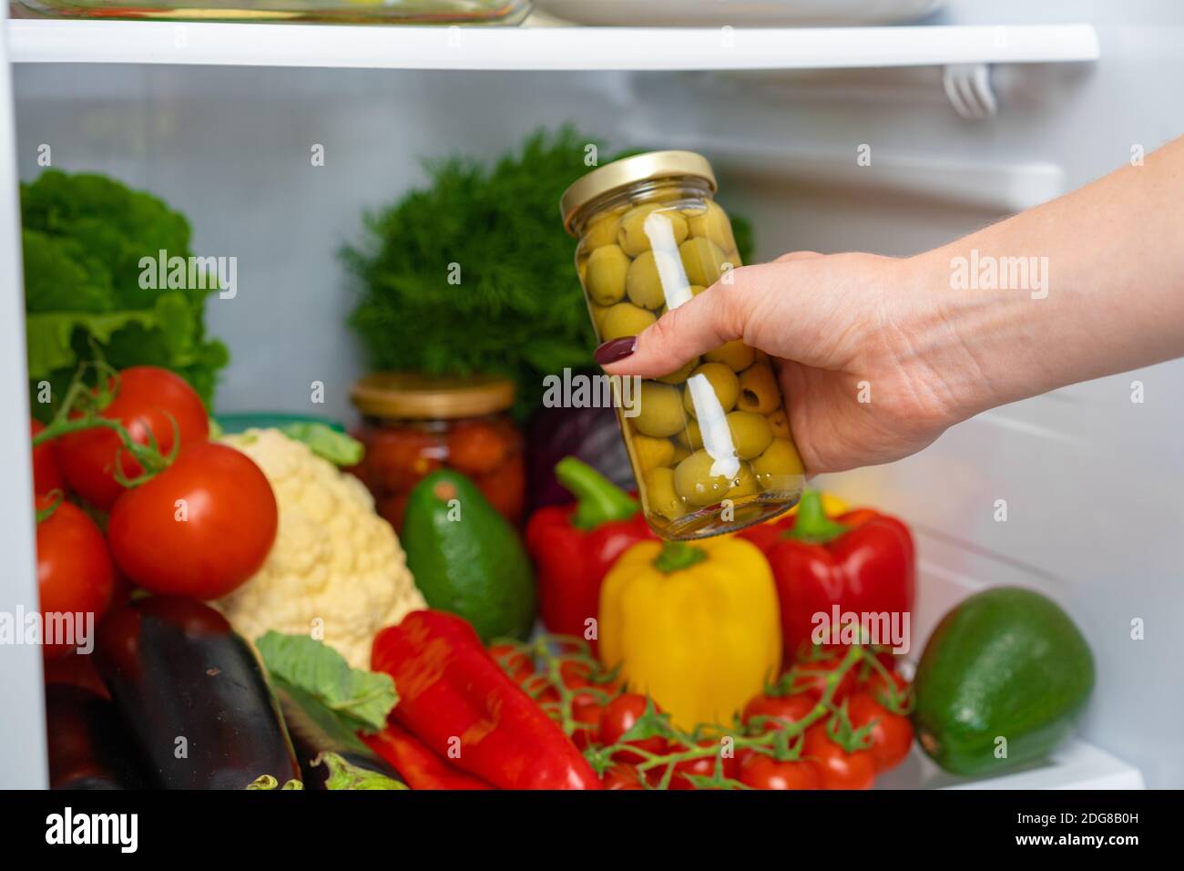 Female hand taking jar of olives from a fridge Stock Photo Alamy