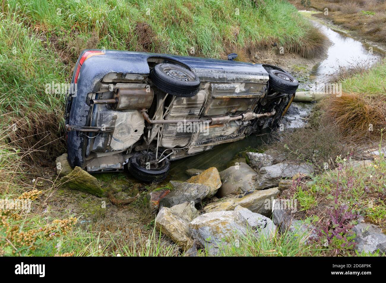 A car crash risks environmental damage as oil and petrol enter a natural waterway Stock Photo