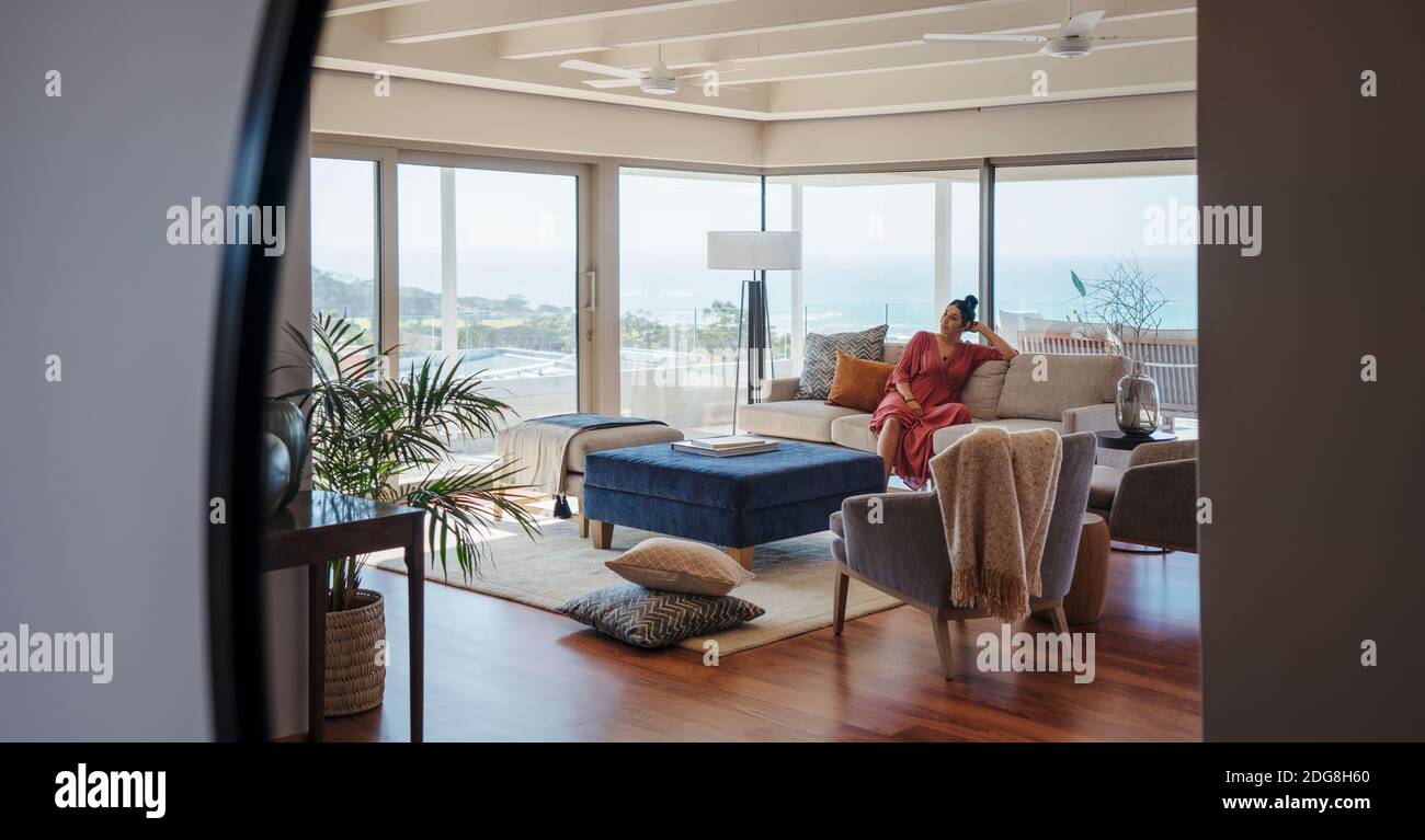 Woman relaxing on sofa in home showcase interior living room Stock Photo