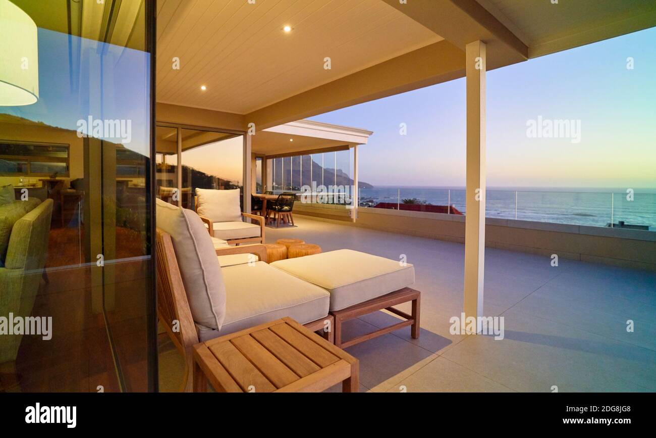 Chaise lounge on luxury patio with sunset ocean view Stock Photo