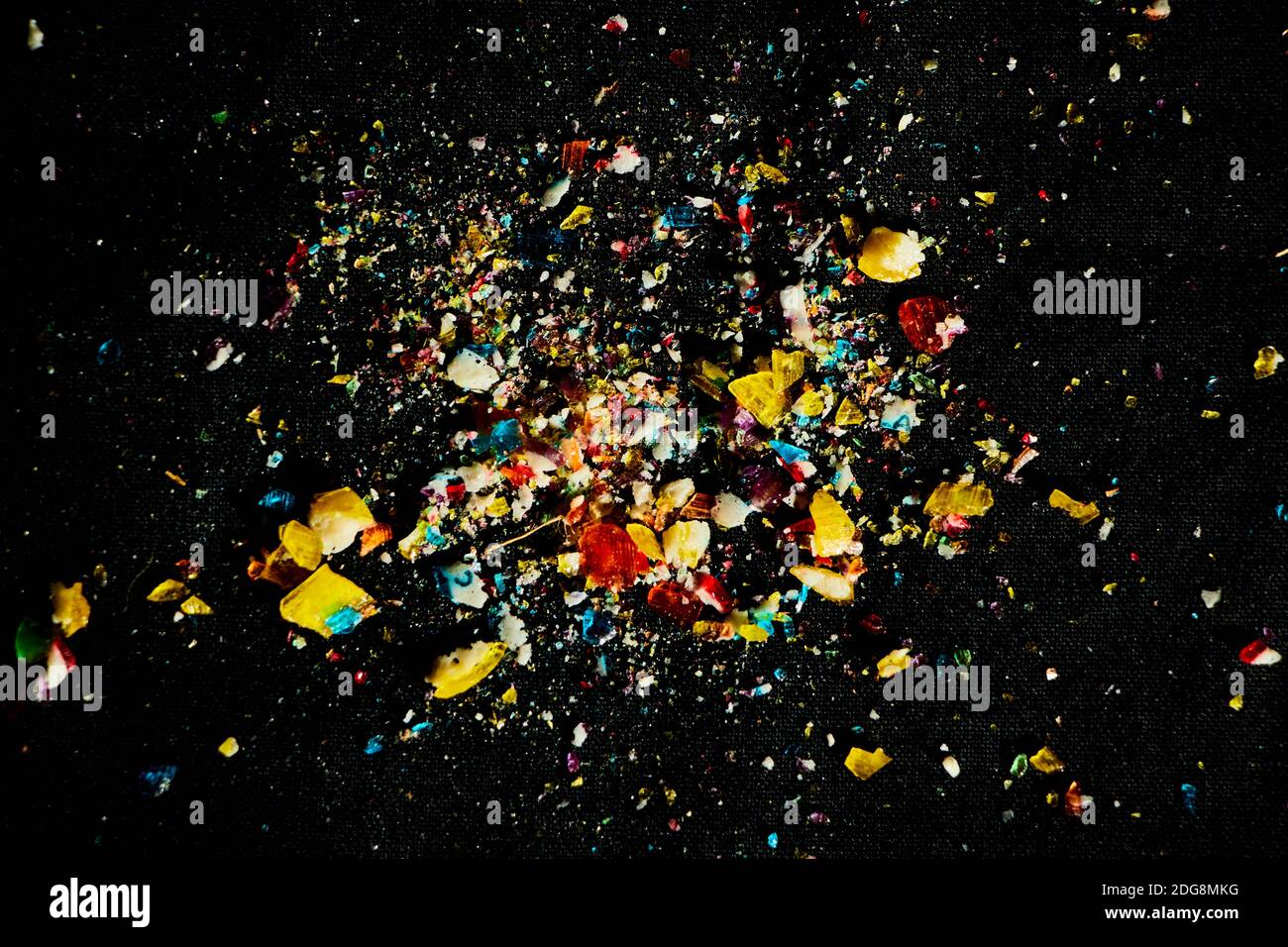 sugar candies falling from glass container on black table background. Empty space for text Stock Photo