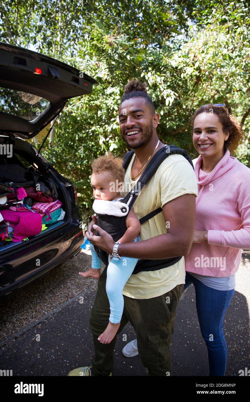 Portrait happy parents with toddler daughter outside car Stock Photo