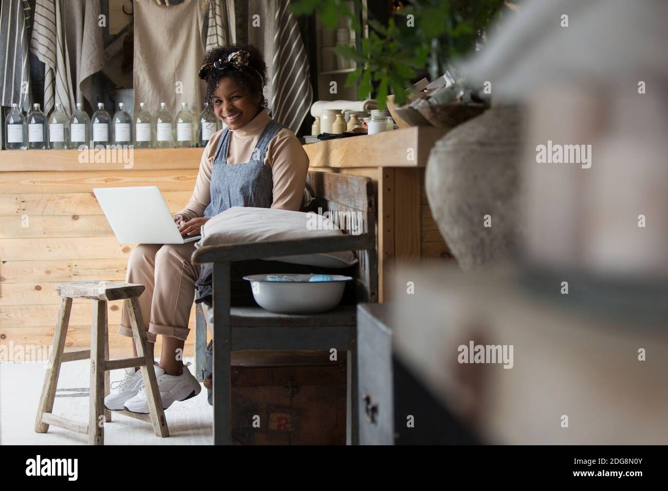 Lady Store Owner Portrait happy female shop owner using laptop in home goods store Stock ...