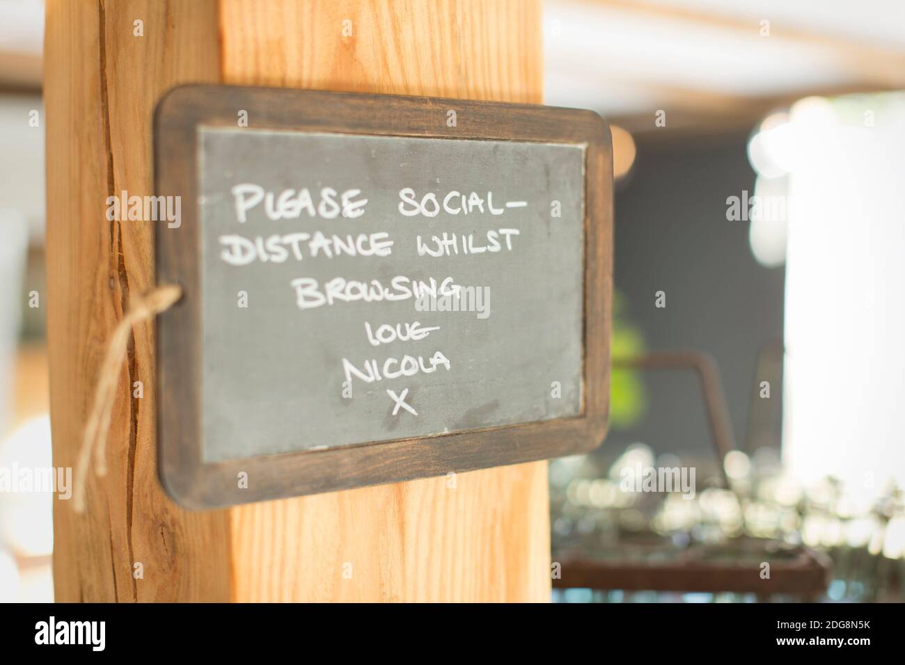 Blackboard social distancing sign in small shop Stock Photo