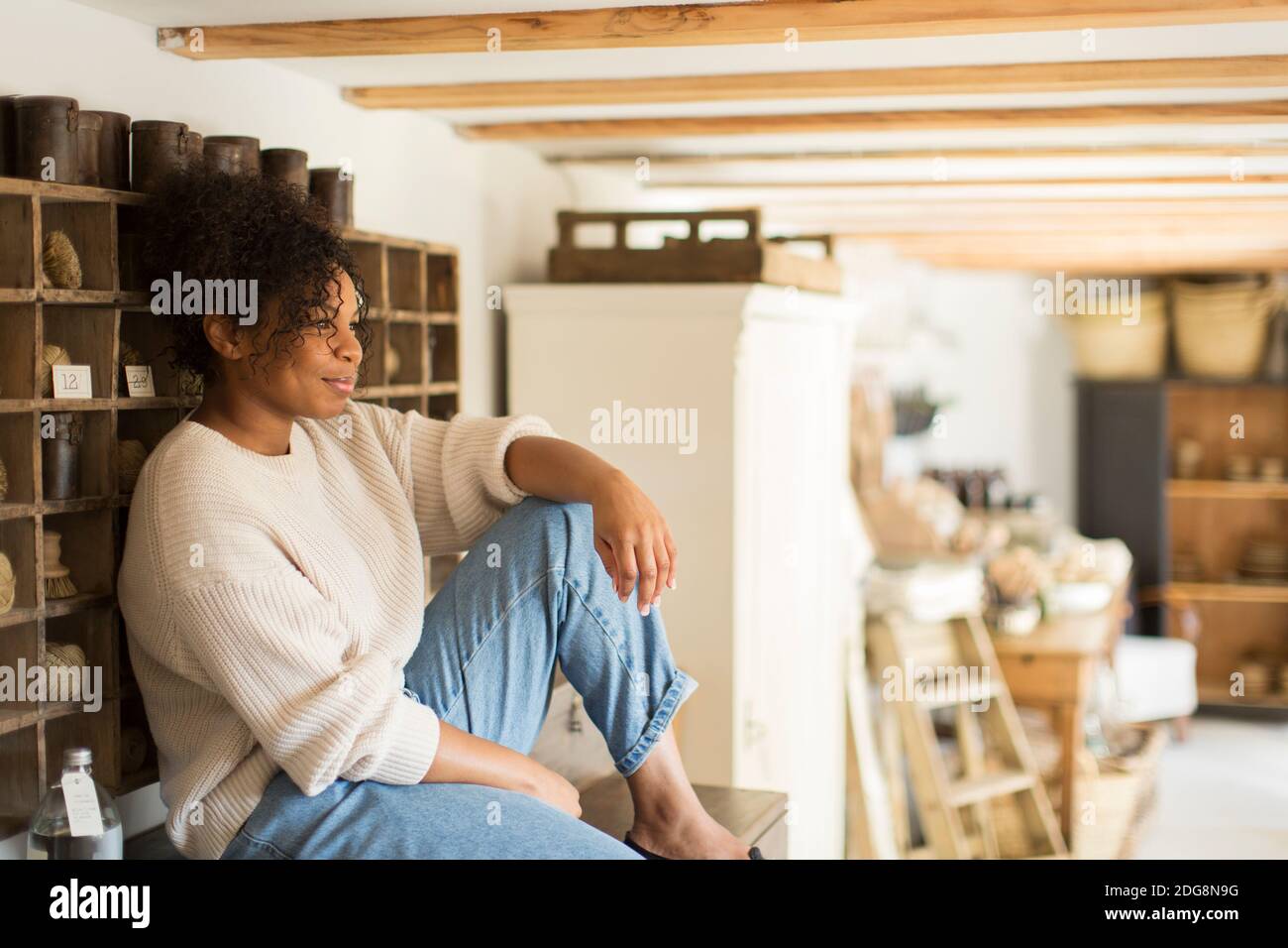 Thoughtful female shop owner looking away Stock Photo