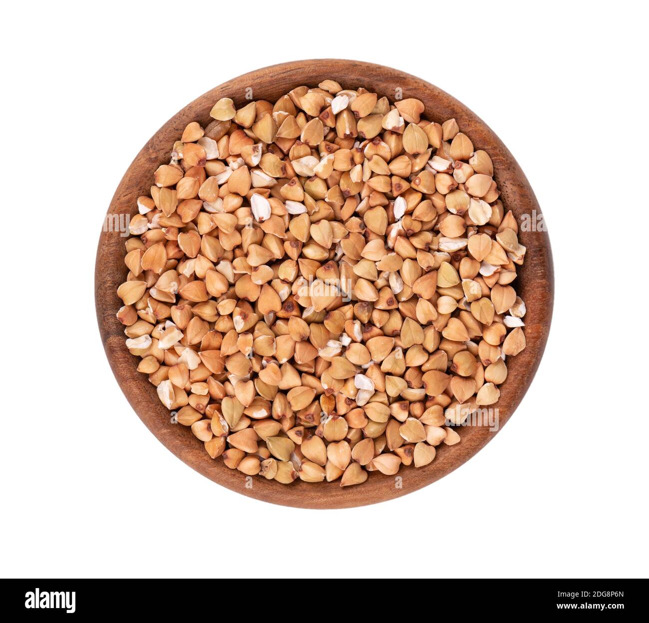Buckwheat groats in wooden bowl, isolated on white background. Green buckwheat seeds. Top view