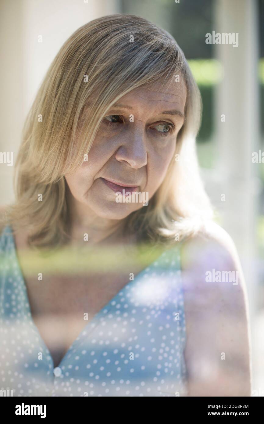 Thoughtful senior woman looking over shoulder Stock Photo