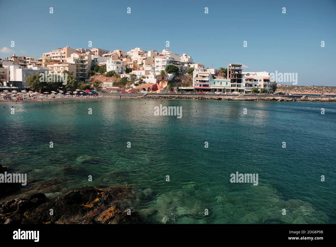 The town of Aghios Nikolaos on Crete with one of its beaches viewed from across the bay Stock Photo