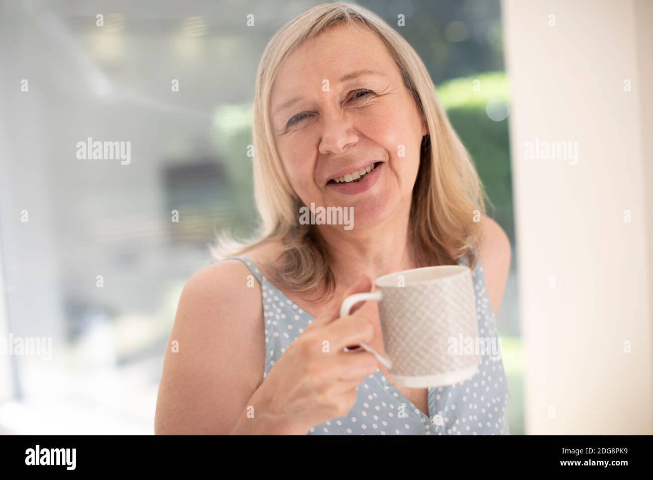 Portrait happy senior woman drinking tea at sunny window Stock Photo ...