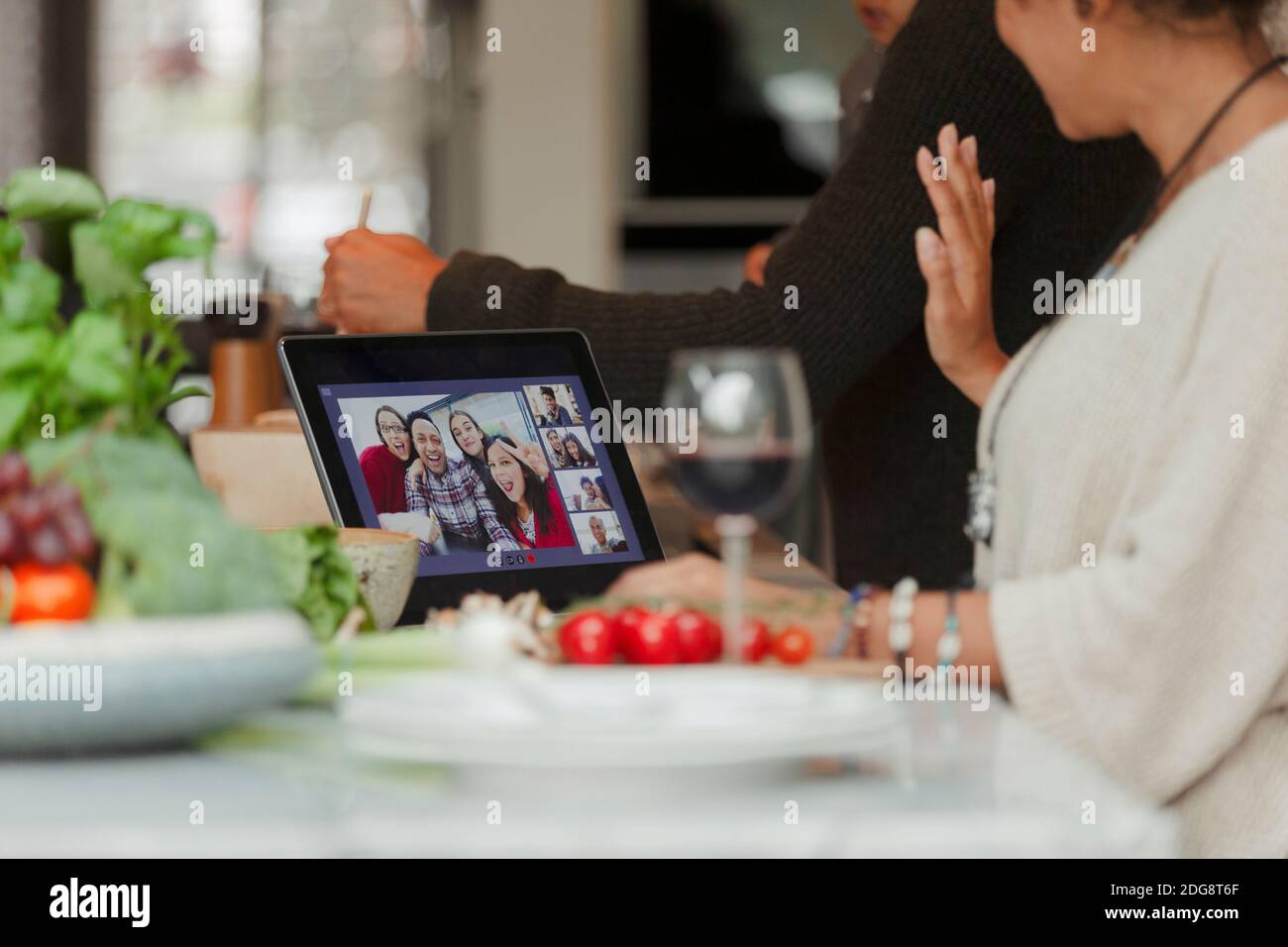 Video Call Dinner Family video chatting on digital tablet screen and preparing dinner ...