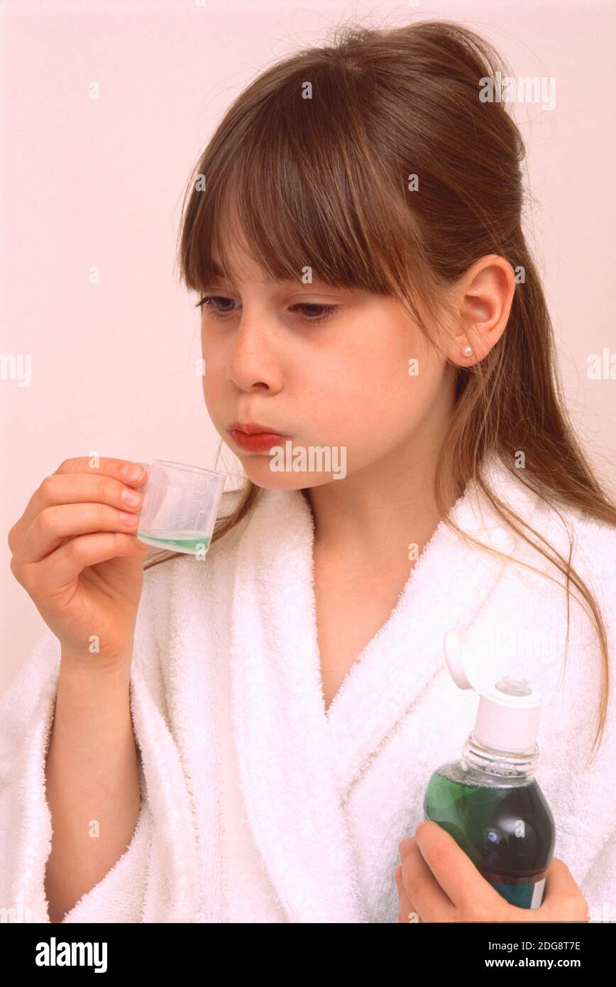 teenager young girl using mouthwash for dental hygiene dressed in white
