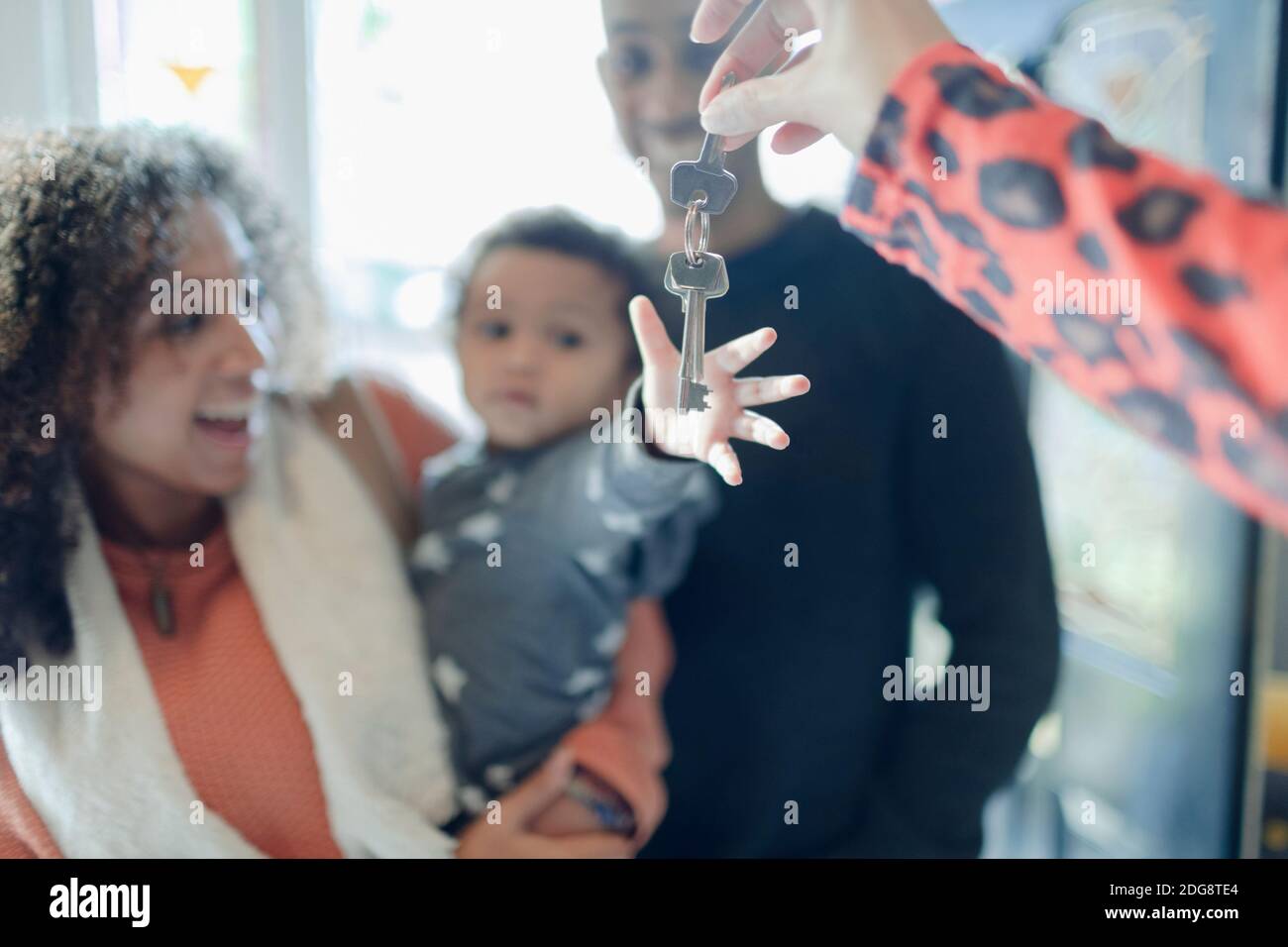 Happy young family receiving new house keys from realtor Stock Photo ...