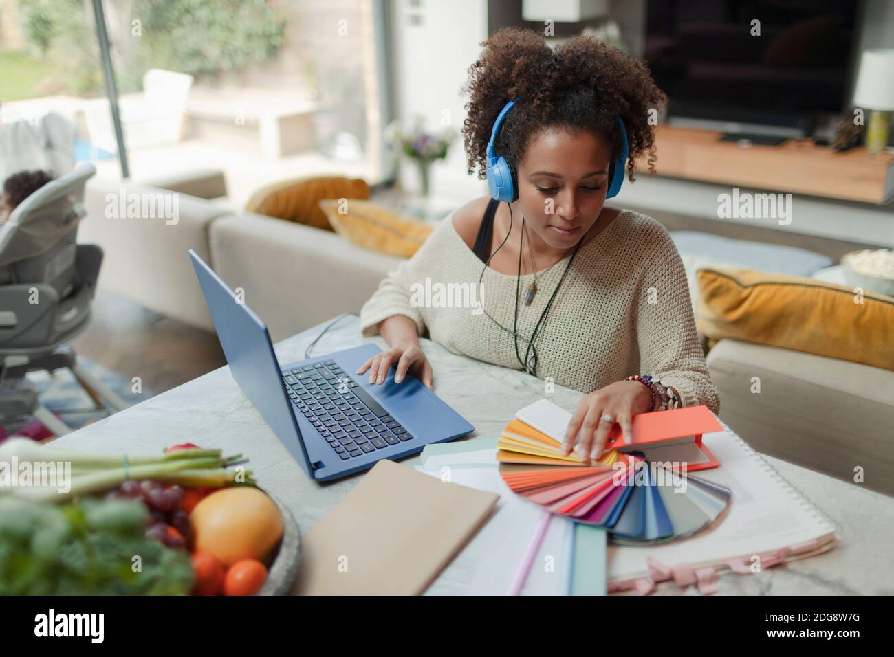 Female designer with color swatches working from home at laptop Stock Photo