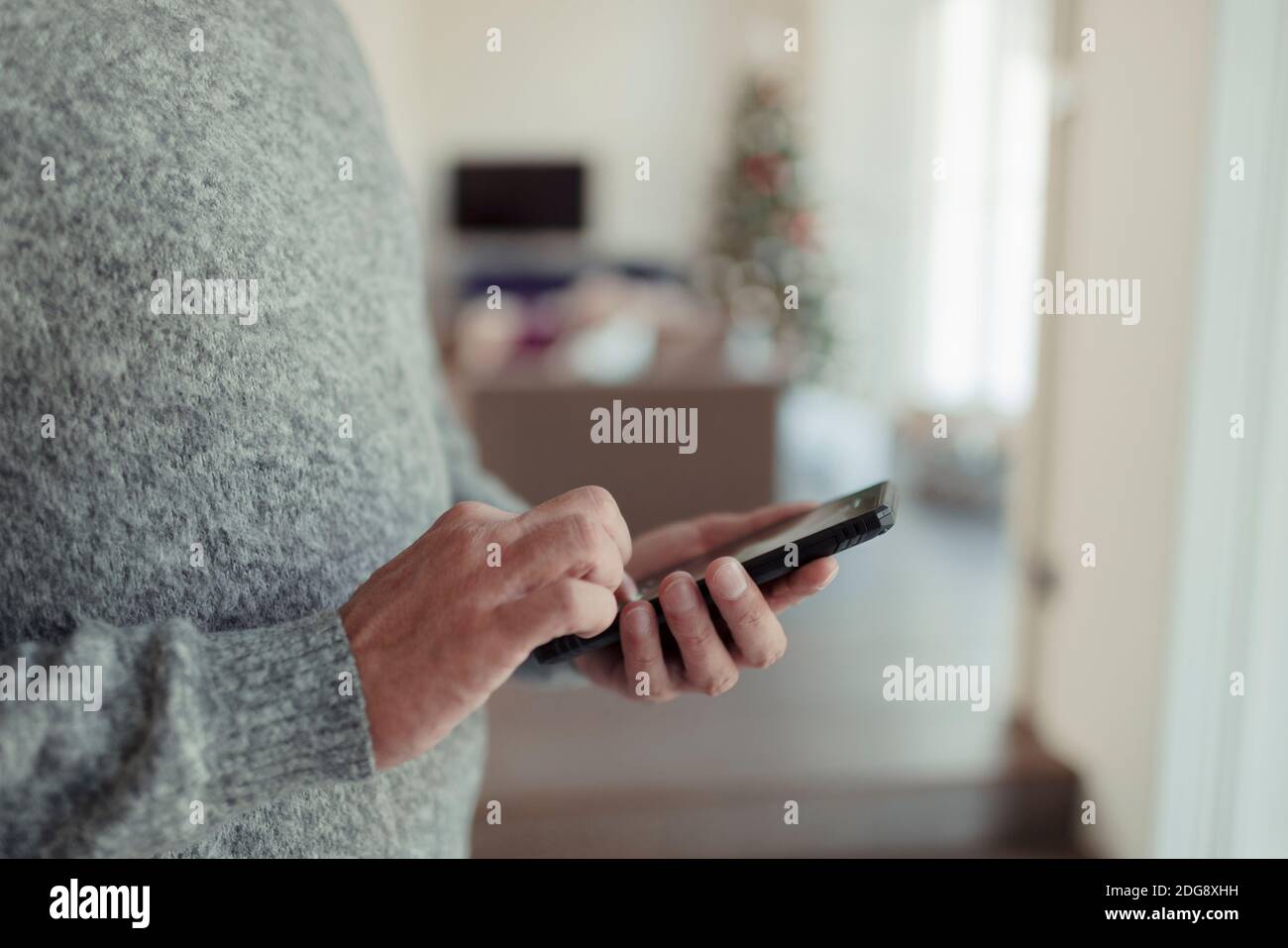 Close up man in sweater using smart phone Stock Photo