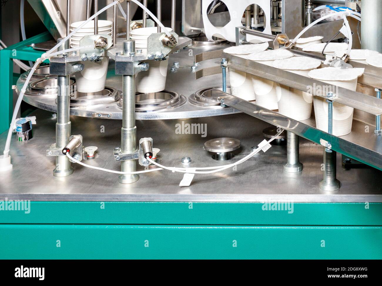 Fragment of the production line for the filling and packaging of yoghurts. Stock Photo