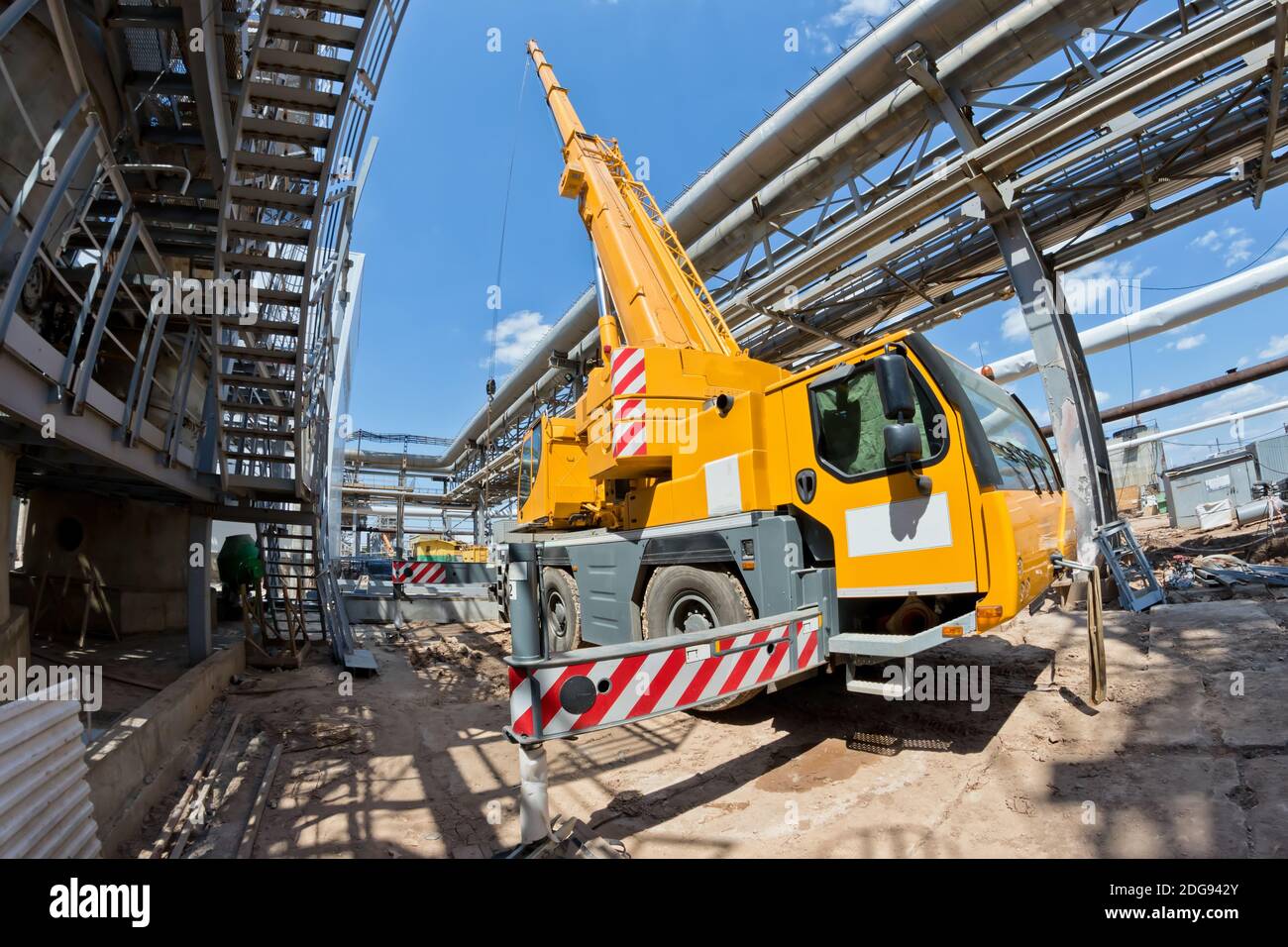Truck crane with spread out legs and an extended boom is at construction site Stock Photo Alamy