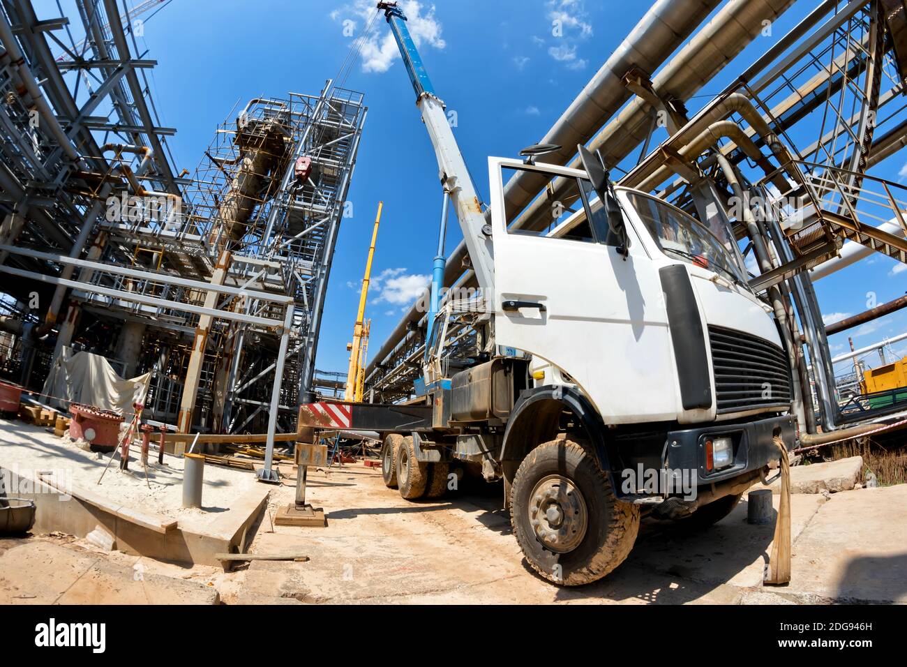 Truck crane with spread out legs and an extended boom is at construction site Stock Photo Alamy