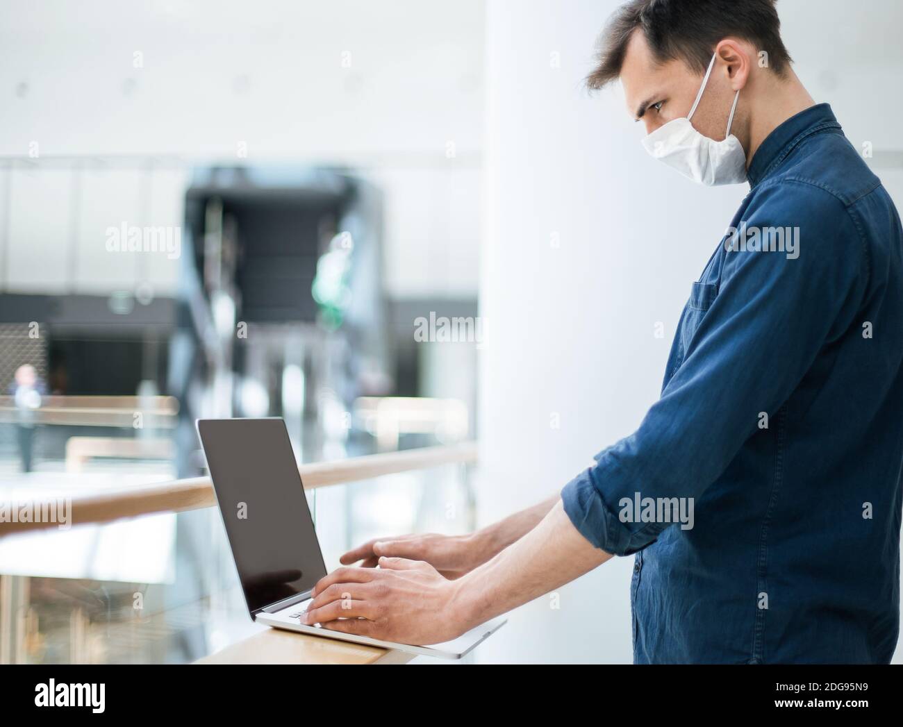 close up. a young man in a protective mask using a laptop Stock Photo