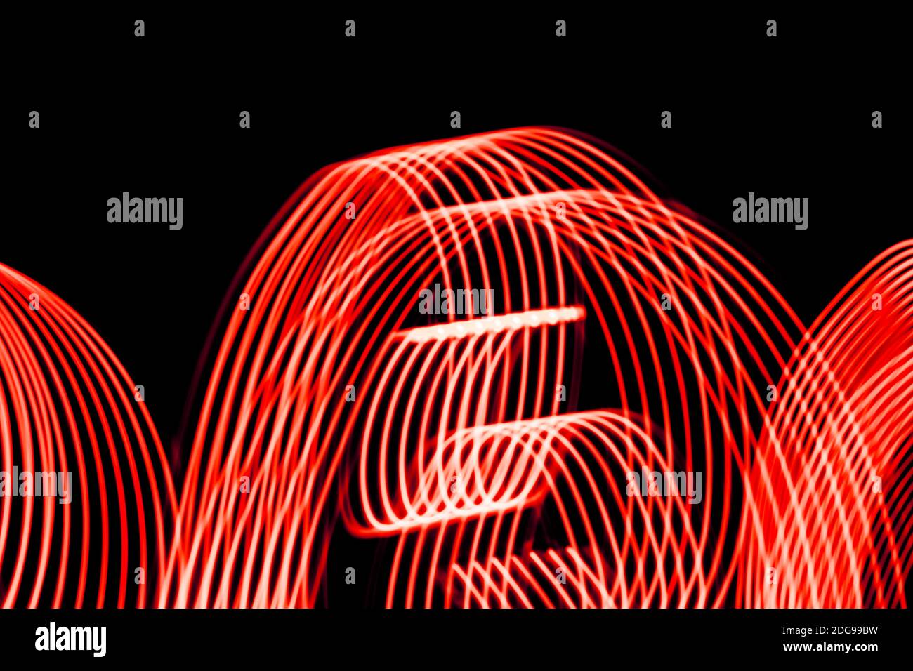 Bright red spiral patterns from light strips on a black background Stock Photo